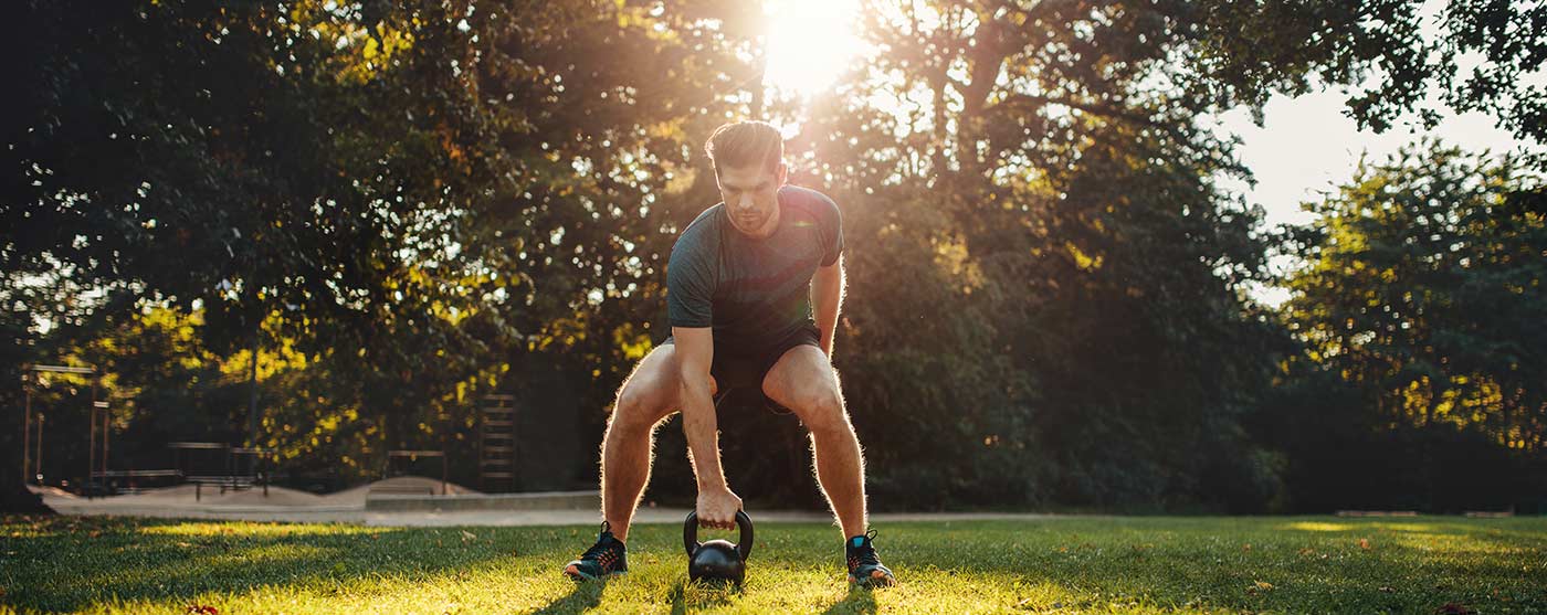Man exercising with kettlebell outside